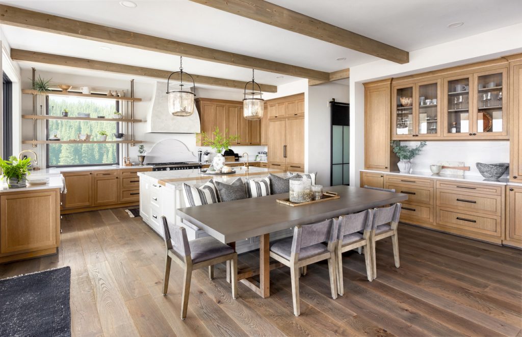 Beautiful Kitchen In New Traditional Style Luxury Home With Island, Pendant Lights, And Hardwood Floors.