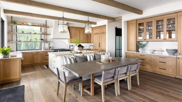 Beautiful Kitchen In New Traditional Style Luxury Home With Island, Pendant Lights, And Hardwood Floors.