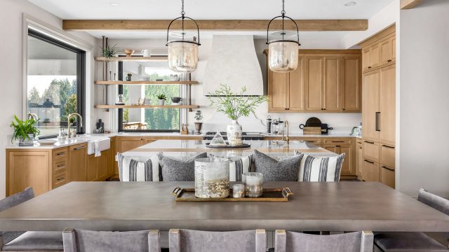 Beautiful Kitchen In New Traditional Style Luxury Home With Island, Pendant Lights, And Hardwood Floors.